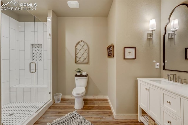 bathroom with an enclosed shower, hardwood / wood-style floors, toilet, and vanity