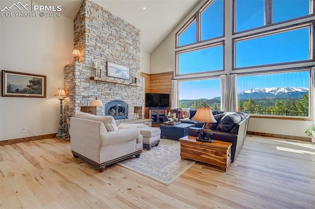 living room featuring high vaulted ceiling, a mountain view, a fireplace, and wood-type flooring