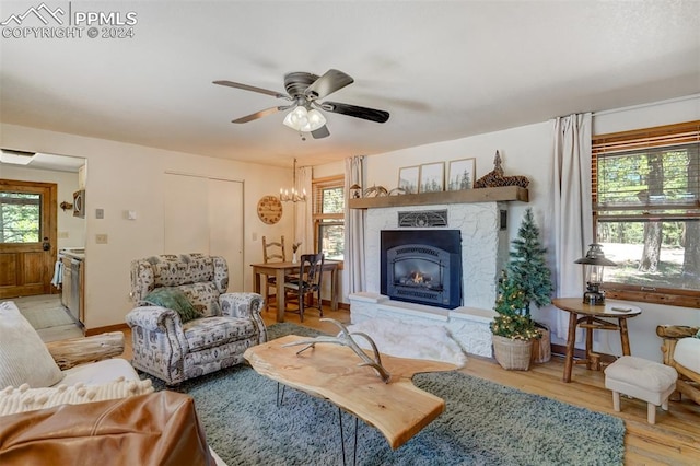 living room with ceiling fan with notable chandelier and hardwood / wood-style floors