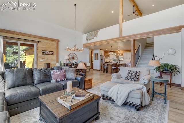 living room with a high ceiling, hardwood / wood-style flooring, and an inviting chandelier