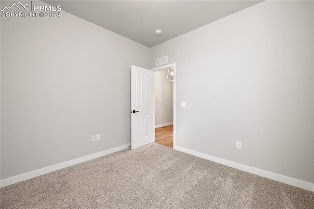 unfurnished room featuring light carpet