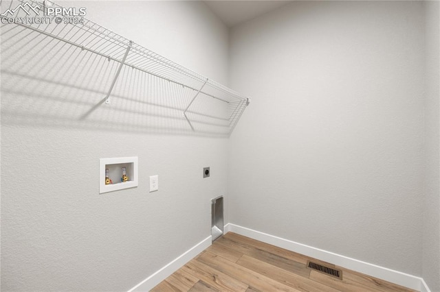 laundry area featuring wood-type flooring, electric dryer hookup, and washer hookup