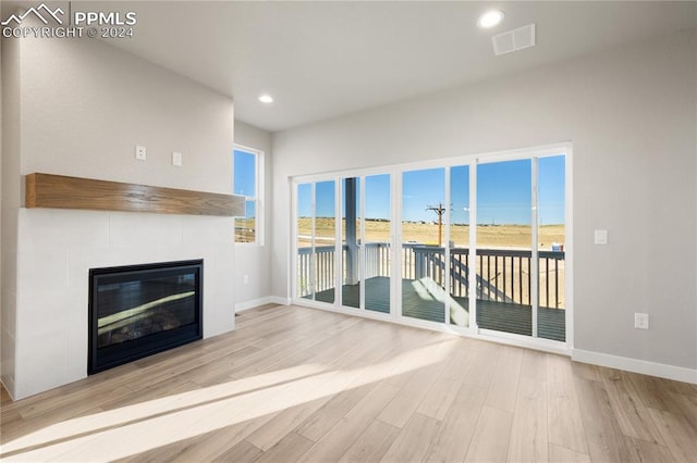 unfurnished living room featuring a fireplace and light wood-type flooring