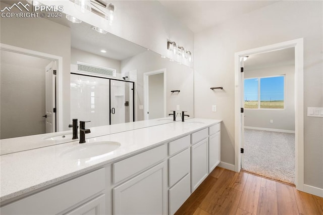 bathroom with vanity, hardwood / wood-style floors, and a shower with shower door