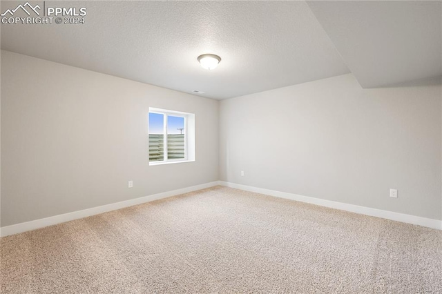 carpeted empty room featuring a textured ceiling