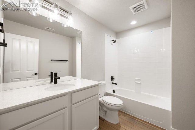 full bathroom with vanity, hardwood / wood-style floors, toilet, and washtub / shower combination