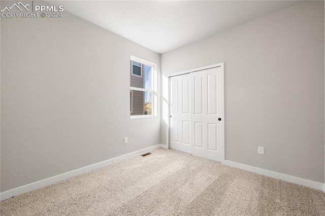 unfurnished bedroom featuring carpet flooring and a closet