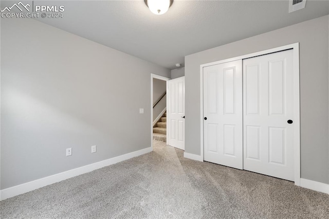 unfurnished bedroom with a closet and carpet flooring