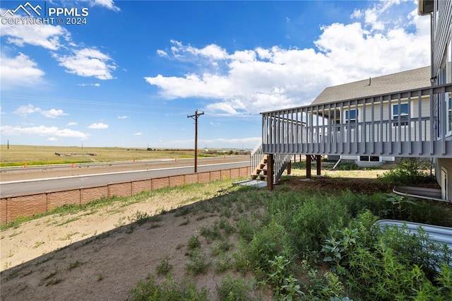 view of yard featuring a wooden deck and a rural view