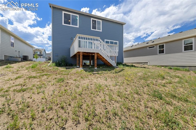 rear view of house featuring a wooden deck