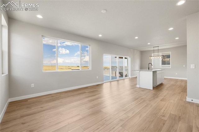 unfurnished living room featuring a healthy amount of sunlight and light wood-type flooring