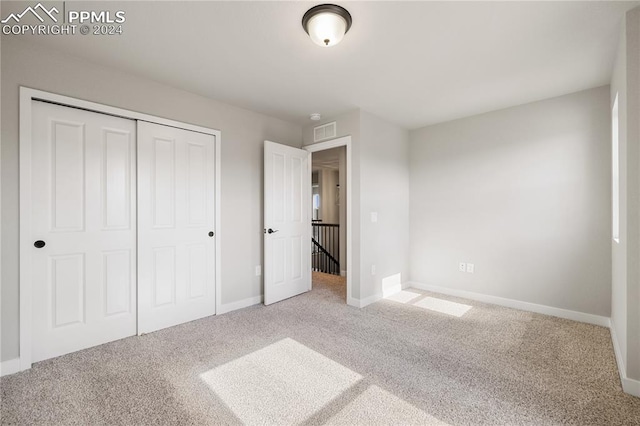 unfurnished bedroom with a closet and carpet floors