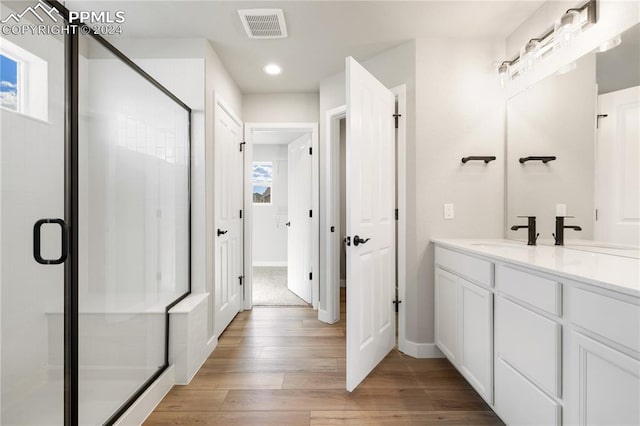 bathroom with a shower with door, vanity, and hardwood / wood-style floors