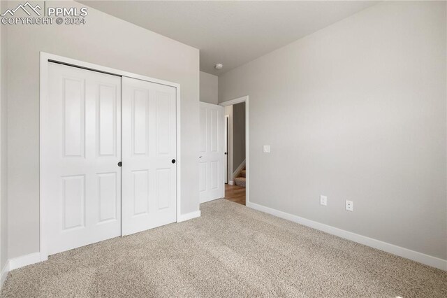 unfurnished bedroom featuring carpet and a closet