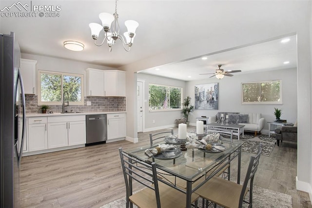 dining area with plenty of natural light, ceiling fan with notable chandelier, and light wood-type flooring