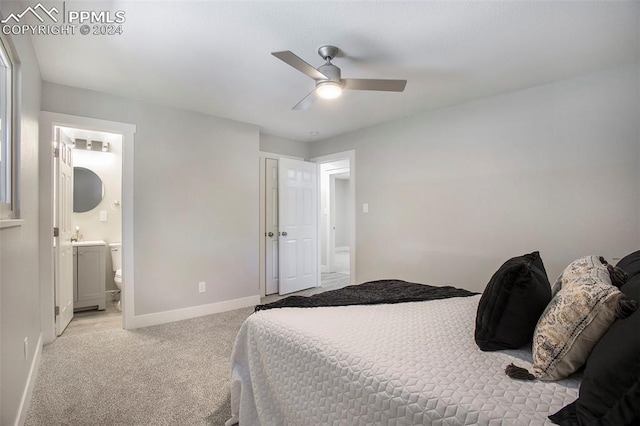 bedroom with light carpet, ensuite bathroom, and ceiling fan