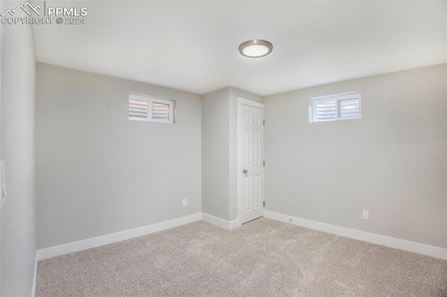 spare room featuring light carpet