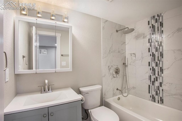 full bathroom featuring tiled shower / bath, vanity, and toilet