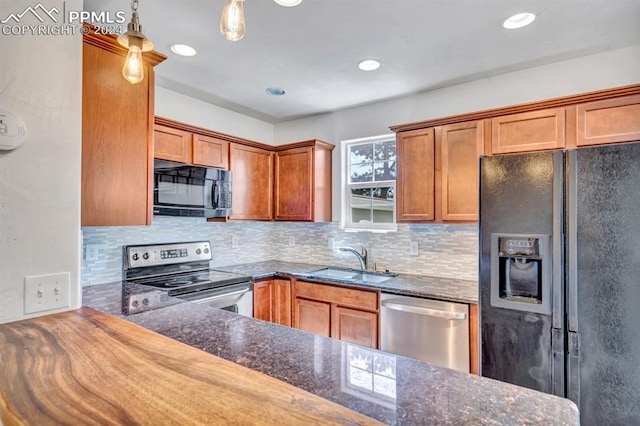 kitchen featuring black appliances, decorative light fixtures, backsplash, and sink