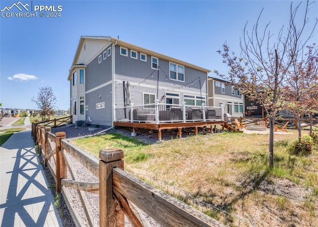 rear view of house featuring central AC and a deck