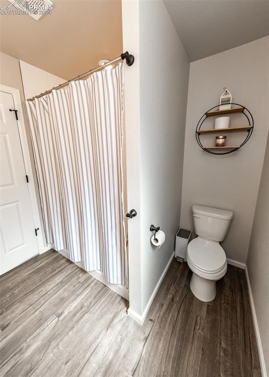 bathroom featuring wood-type flooring and toilet