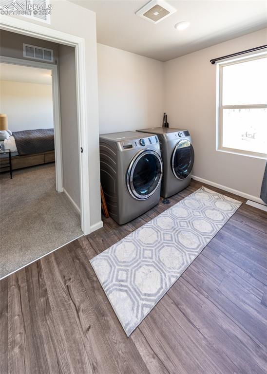 laundry area with dark hardwood / wood-style flooring and separate washer and dryer