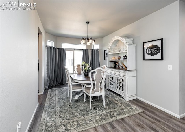 dining room featuring dark hardwood / wood-style flooring and an inviting chandelier