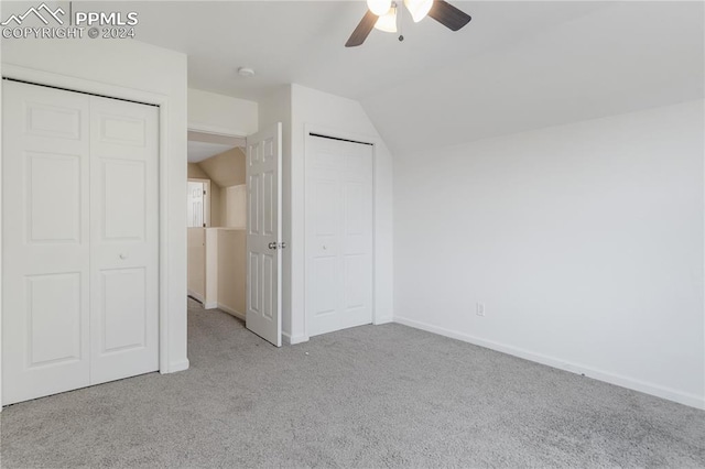 unfurnished bedroom featuring ceiling fan, lofted ceiling, and light carpet