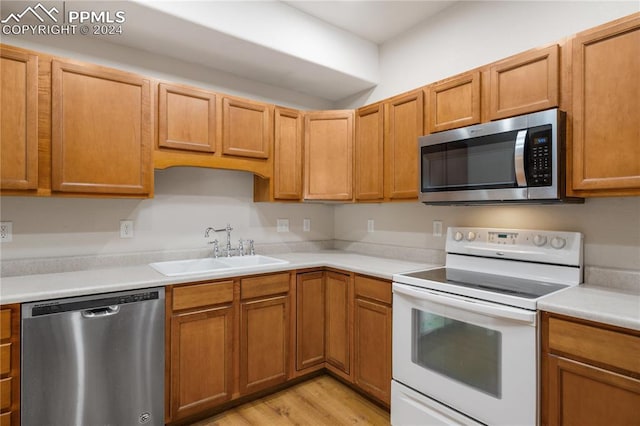 kitchen featuring sink, appliances with stainless steel finishes, and light hardwood / wood-style flooring