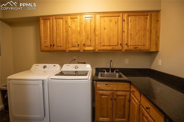 laundry area with washing machine and clothes dryer, sink, and cabinets