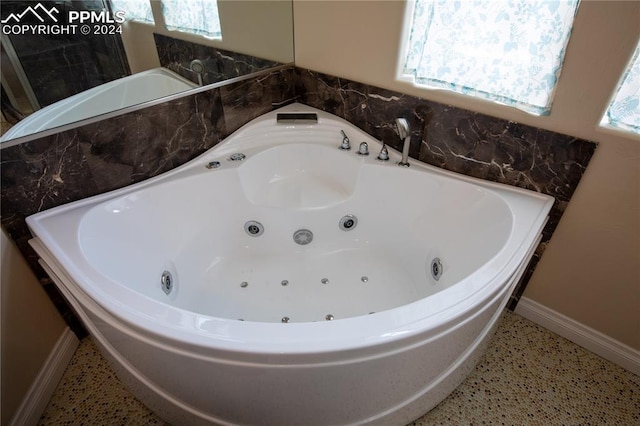 bathroom featuring plenty of natural light and a bath