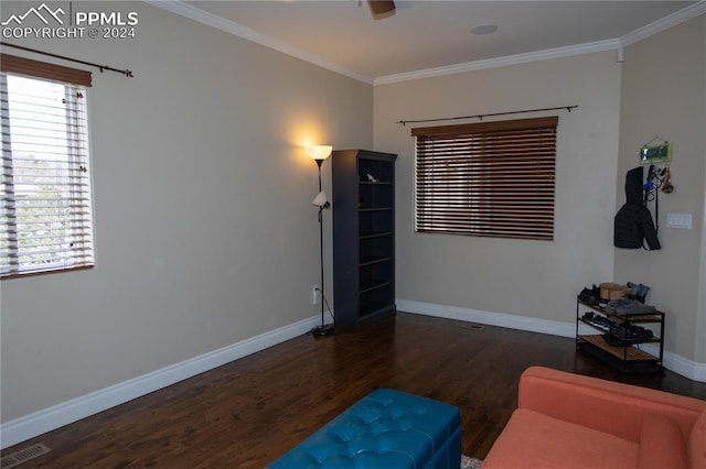 living area featuring ceiling fan, crown molding, dark wood-type flooring, and a wealth of natural light