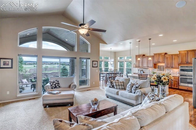 carpeted living room featuring high vaulted ceiling, ceiling fan, and a wealth of natural light