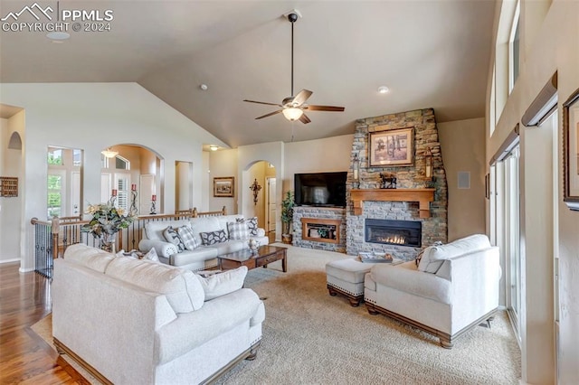 living room with a fireplace, wood-type flooring, high vaulted ceiling, and ceiling fan