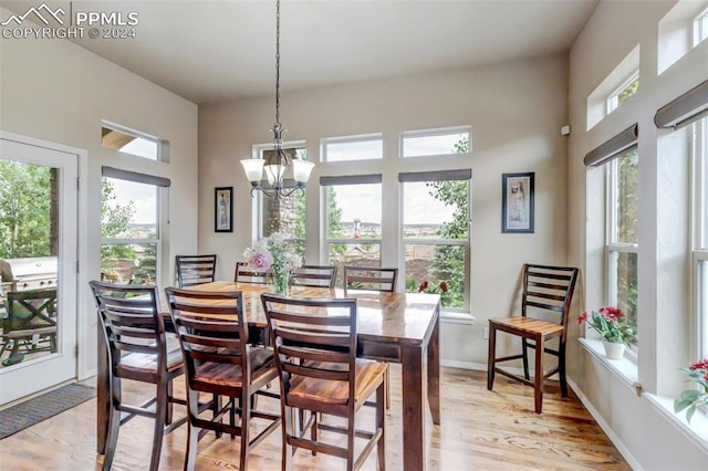 dining space with light wood-type flooring and a notable chandelier