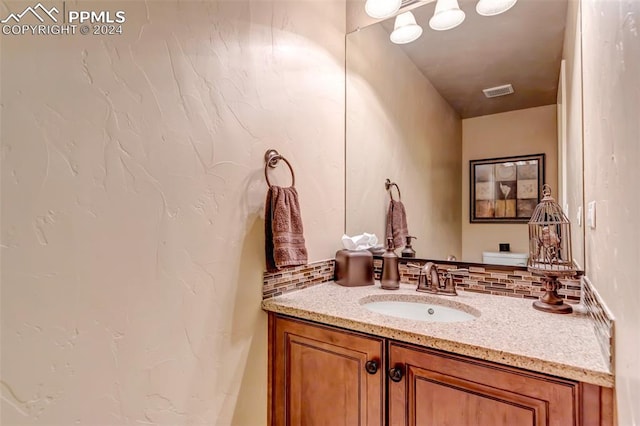 bathroom with decorative backsplash and vanity