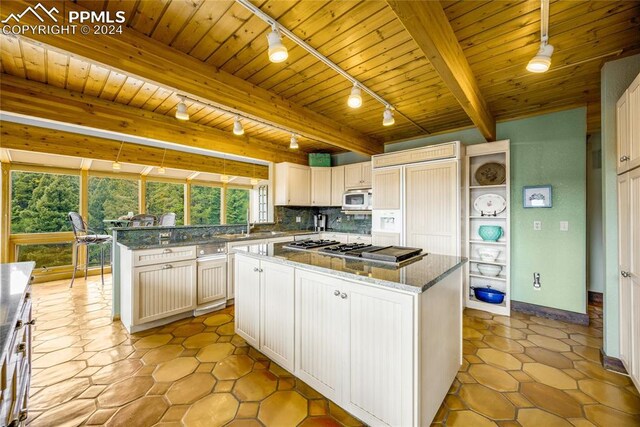 kitchen featuring a kitchen island, beamed ceiling, backsplash, wood ceiling, and light tile floors