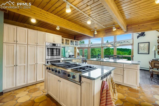 kitchen featuring beamed ceiling, wood ceiling, a kitchen island, and stainless steel appliances