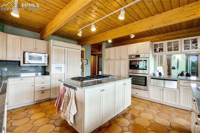 kitchen featuring a kitchen island, backsplash, built in appliances, beam ceiling, and wood ceiling