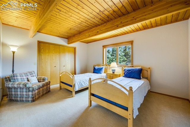 carpeted bedroom with beamed ceiling, a closet, and wooden ceiling