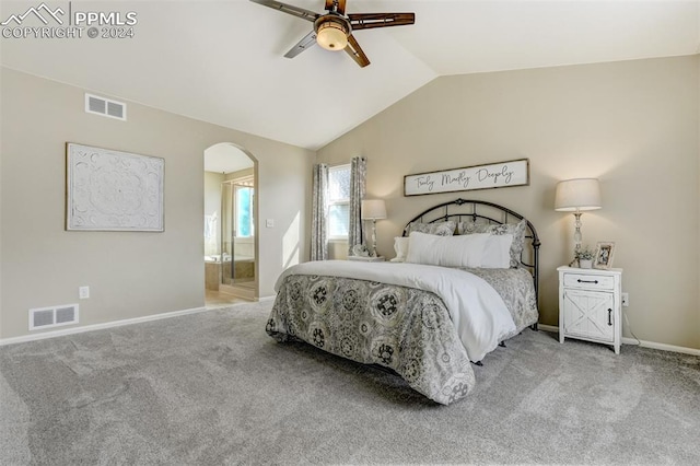 bedroom featuring lofted ceiling, connected bathroom, light colored carpet, and ceiling fan