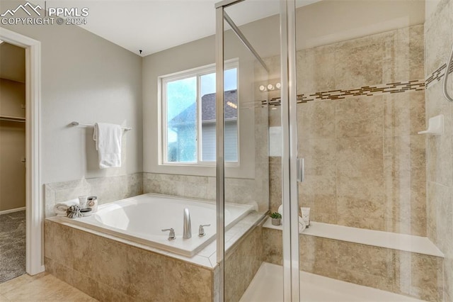 bathroom featuring tile patterned floors and separate shower and tub