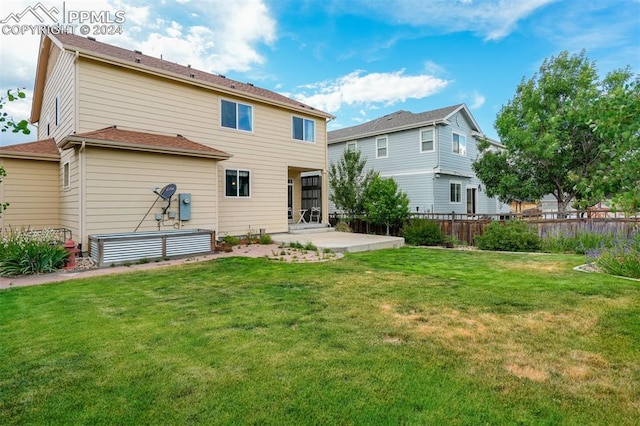 rear view of property featuring a lawn