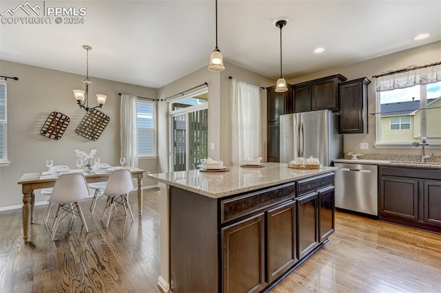 kitchen with dark brown cabinetry, appliances with stainless steel finishes, sink, and hanging light fixtures