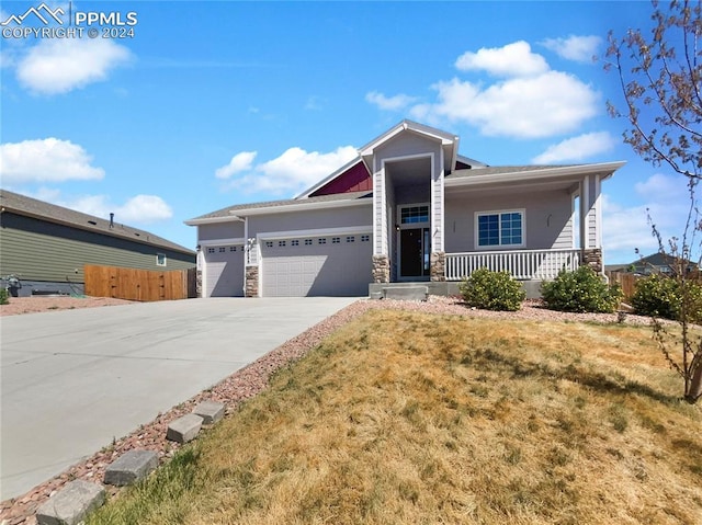 view of front of home with a front lawn, a porch, and a garage