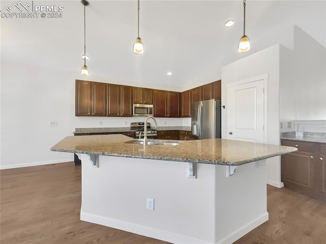 kitchen featuring hanging light fixtures, a breakfast bar, sink, and stainless steel appliances