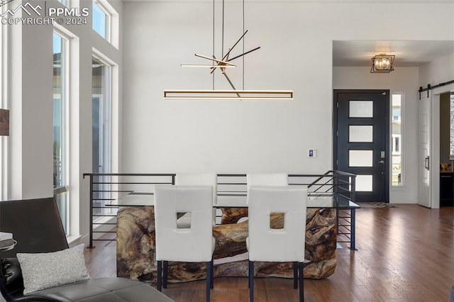 dining room with dark hardwood / wood-style flooring and a barn door