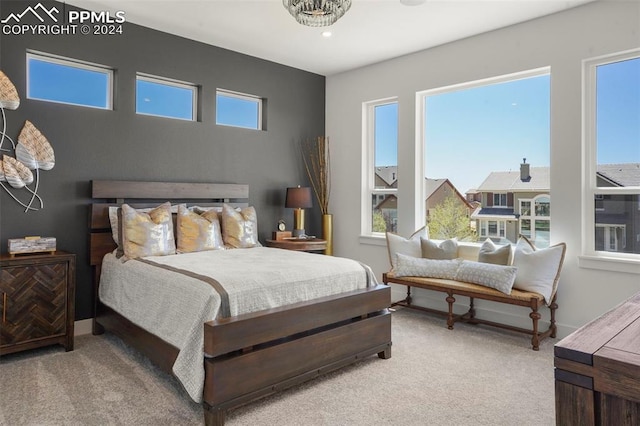 carpeted bedroom featuring a notable chandelier