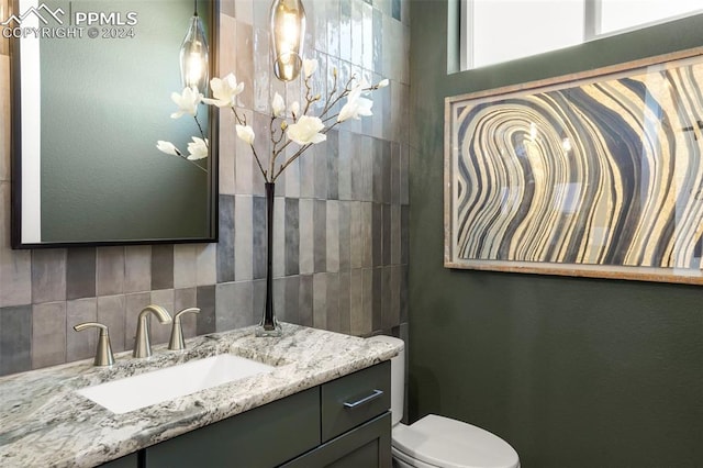 bathroom with vanity, toilet, and a chandelier