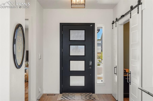 entryway with a barn door and light wood-type flooring